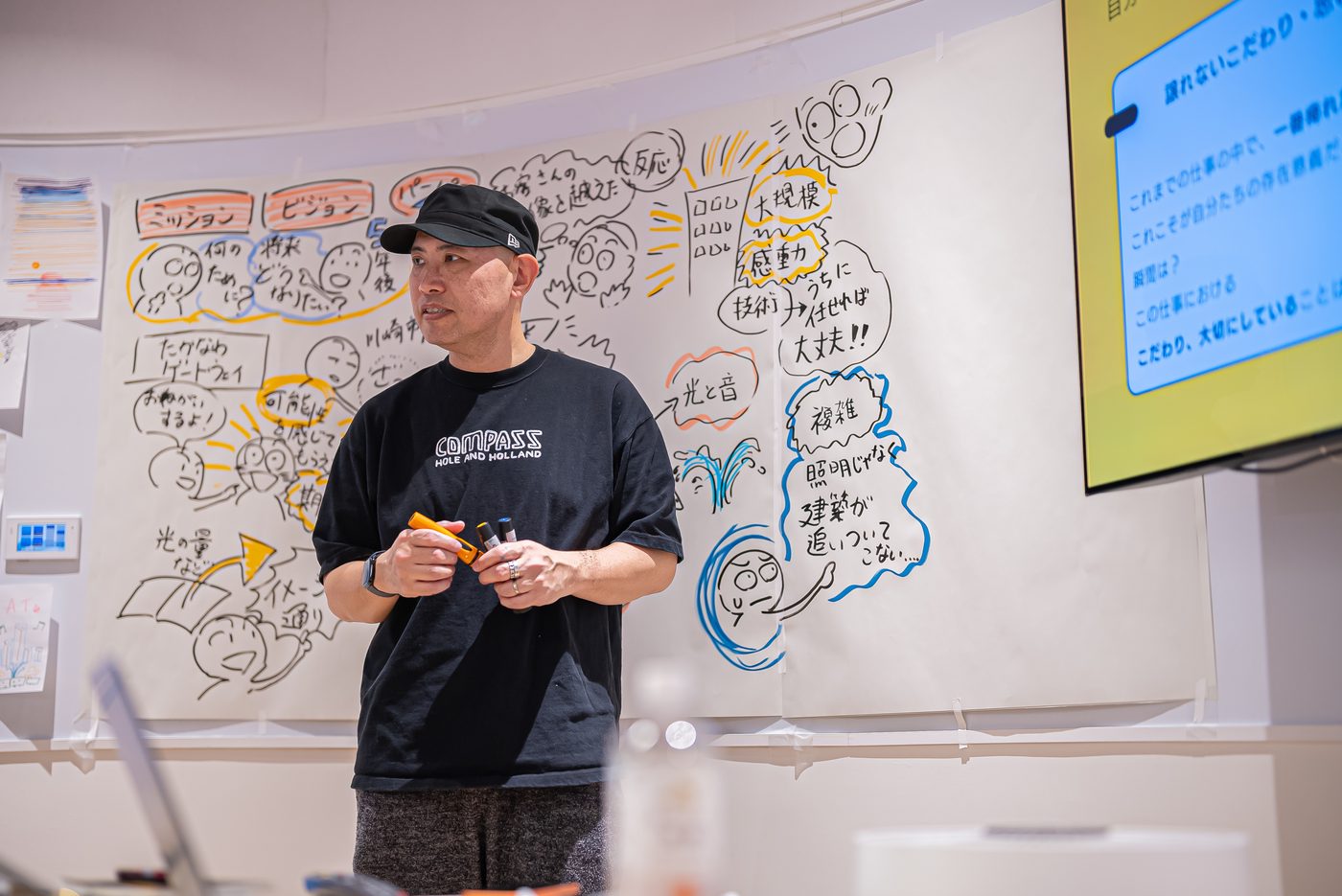 描いたグラフィックの前で参加者に語りかける丸山